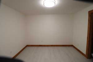 Empty room featuring baseboards and light wood-style floors