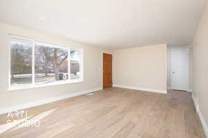 Empty room with baseboards and light wood finished floors