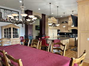Dining room featuring an inviting chandelier, light wood-type flooring, arched walkways, and recessed lighting