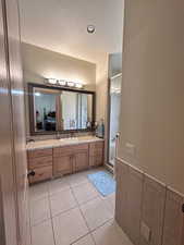 Full bath featuring a stall shower, recessed lighting, tile patterned flooring, vanity, and a wainscoted wall