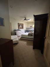 Carpeted bedroom featuring a ceiling fan