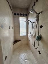 Full bath featuring tiled shower