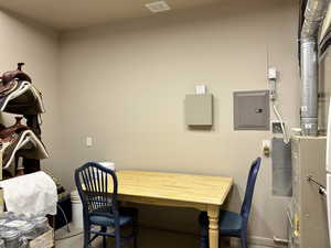 Office area featuring electric panel, baseboards, and visible vents