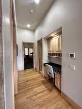 Corridor with light wood finished floors, baseboards, and recessed lighting