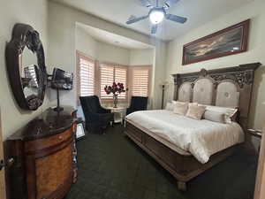 Bedroom with a ceiling fan and dark carpet