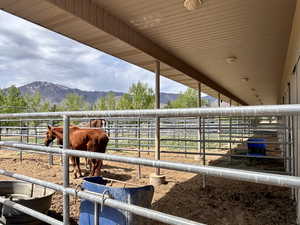 View of stable featuring a mountain view and a rural view