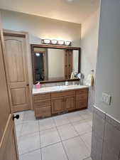 Bathroom featuring tile walls, tile patterned floors, vanity, and wainscoting