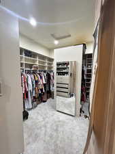 Spacious closet with attic access and carpet