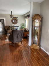 Living room featuring a textured ceiling, wood-type flooring, and a ceiling fan