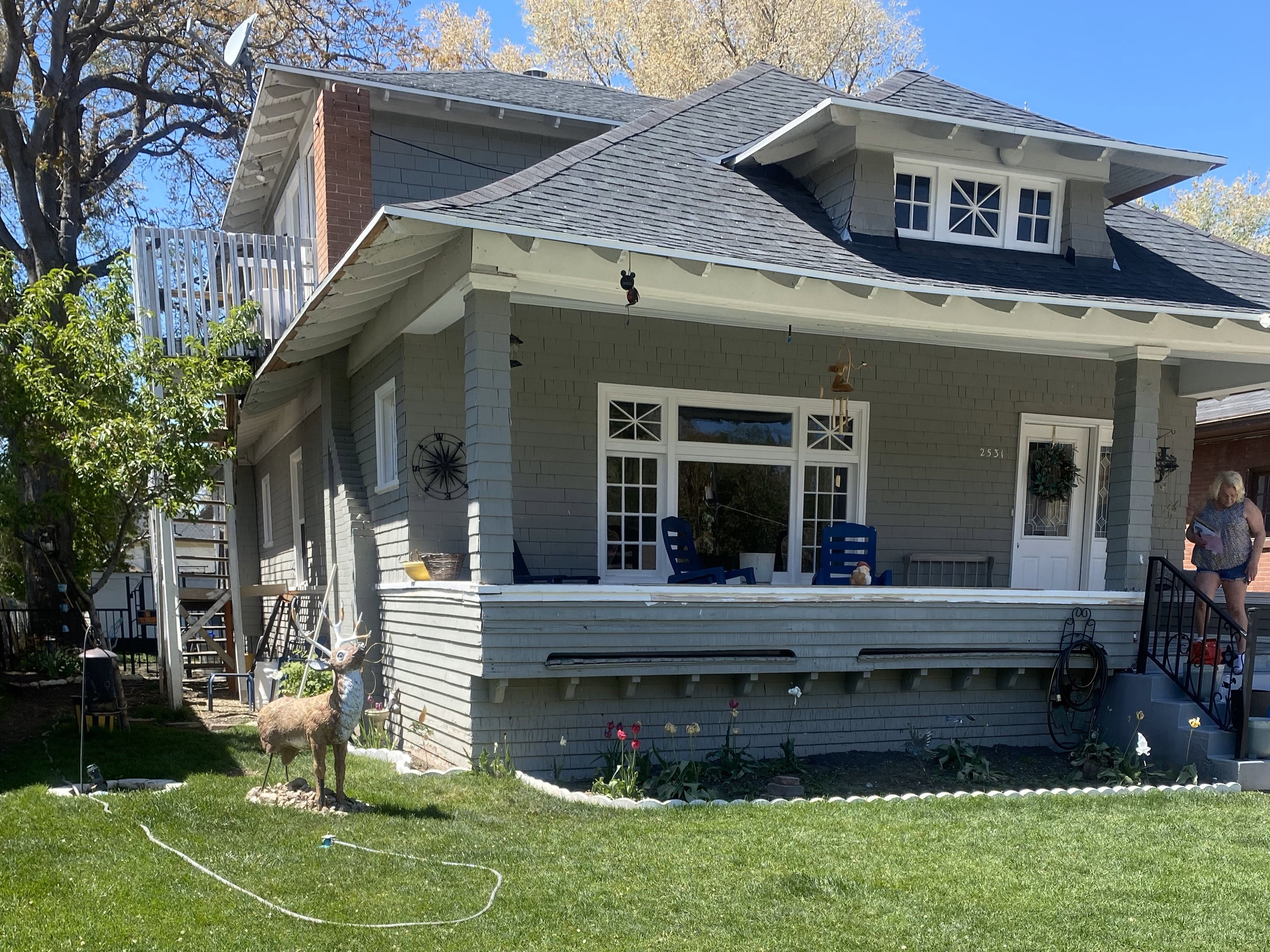 Exterior space featuring covered porch, a front yard, and a shingled roof