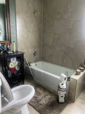 Full bath featuring tile patterned floors and shower / bath combination