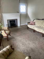 Living area with a fireplace, carpet flooring, and baseboards