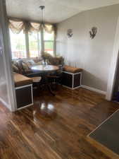 Dining area featuring a textured ceiling, wood finished floors, and baseboards