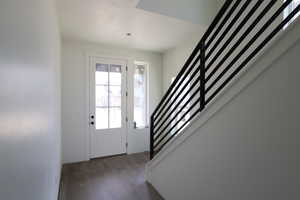 Foyer entrance with stairs and wood finished floors