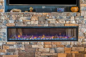 Exterior details featuring a glass covered fireplace and stone siding