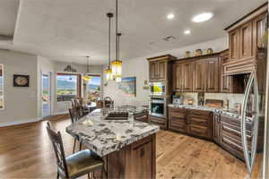 Kitchen featuring a sink, appliances with stainless steel finishes, a breakfast bar, and a textured ceiling