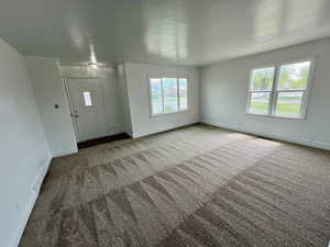 Carpeted entryway featuring baseboards and visible vents