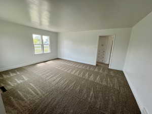 Carpeted spare room with baseboards and visible vents