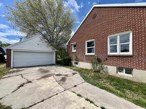 View of home's exterior with an outdoor structure, brick siding, and a garage