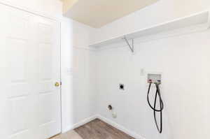 Laundry room featuring baseboards, hookup for a washing machine, wood finished floors, laundry area, and electric dryer hookup