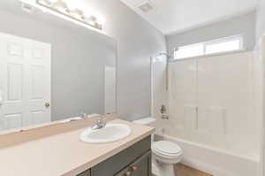 Full bath featuring toilet, shower / bathtub combination, vanity, and visible vents