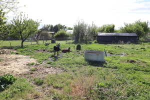 View of yard with fence and a rural view
