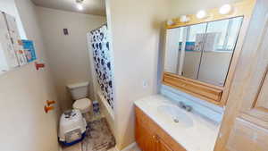 Bathroom with vanity, toilet, and baseboards