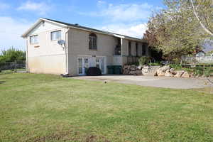 Rear view of house with fence, french doors, brick siding, and a lawn