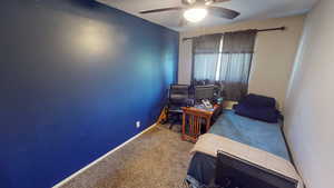 Carpeted bedroom featuring baseboards, ceiling fan, and a textured ceiling