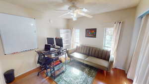 Living room with baseboards, ceiling fan, and wood finished floors