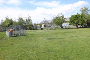 View of yard with an outdoor structure, exterior structure, and fence
