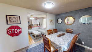 Dining area with ceiling fan and a textured ceiling