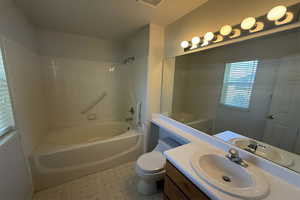 Bathroom with toilet, bathtub / shower combination, tile patterned floors, visible vents, and vanity