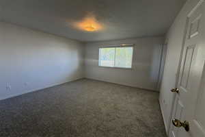 Spare room featuring baseboards and carpet floors