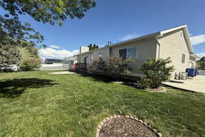 Back of property featuring a lawn and fence