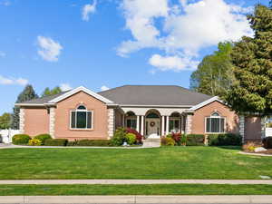 Single story home featuring all brick, fence, and a front yard