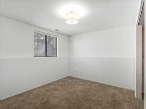 Unfurnished room with carpet flooring and visible vents