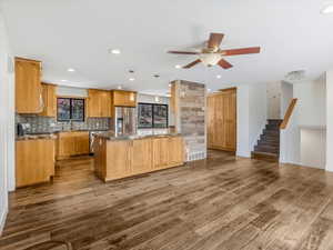 Kitchen with backsplash, dark wood-type flooring, a ceiling fan, and appliances with stainless steel finishes