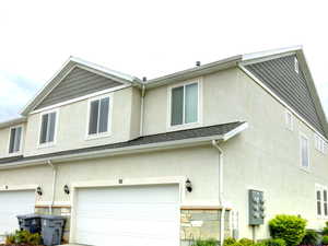 View of home's exterior with a lawn, stucco siding, a garage, and concrete driveway