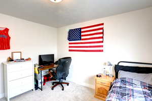 Bedroom featuring light colored carpet and baseboards