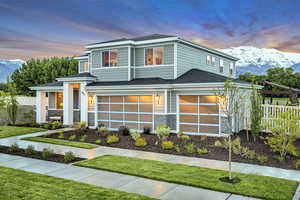 Modern home featuring a front yard, a mountain view, fence, and a garage