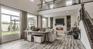 Living area featuring a wealth of natural light, wood finished floors, baseboards, and stairs