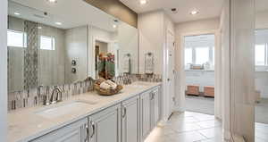 Primary bathroom featuring an extended walk in shower, and two sinks