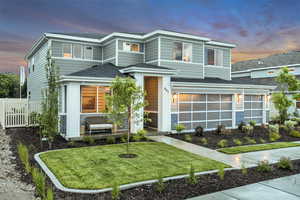 View of front of house featuring a front yard, roof with shingles, an attached garage, and fence