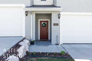 Property entrance with driveway and stucco siding