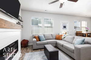 Living room featuring baseboards, a ceiling fan, visible vents, and light wood-style floors