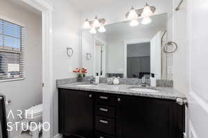 Full bathroom featuring a sink, double vanity, and toilet