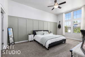 Carpeted bedroom with a decorative wall and a ceiling fan