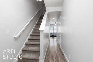 Stairs featuring ceiling fan, baseboards, and wood finished floors