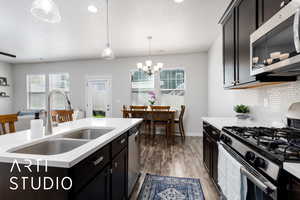 Kitchen with light countertops, appliances with stainless steel finishes, a healthy amount of sunlight, and a sink